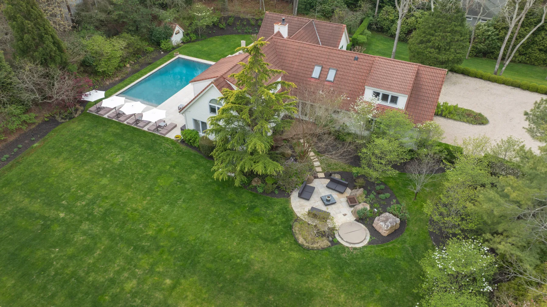 Vista aérea de una casa con piscina y césped ajardinado.