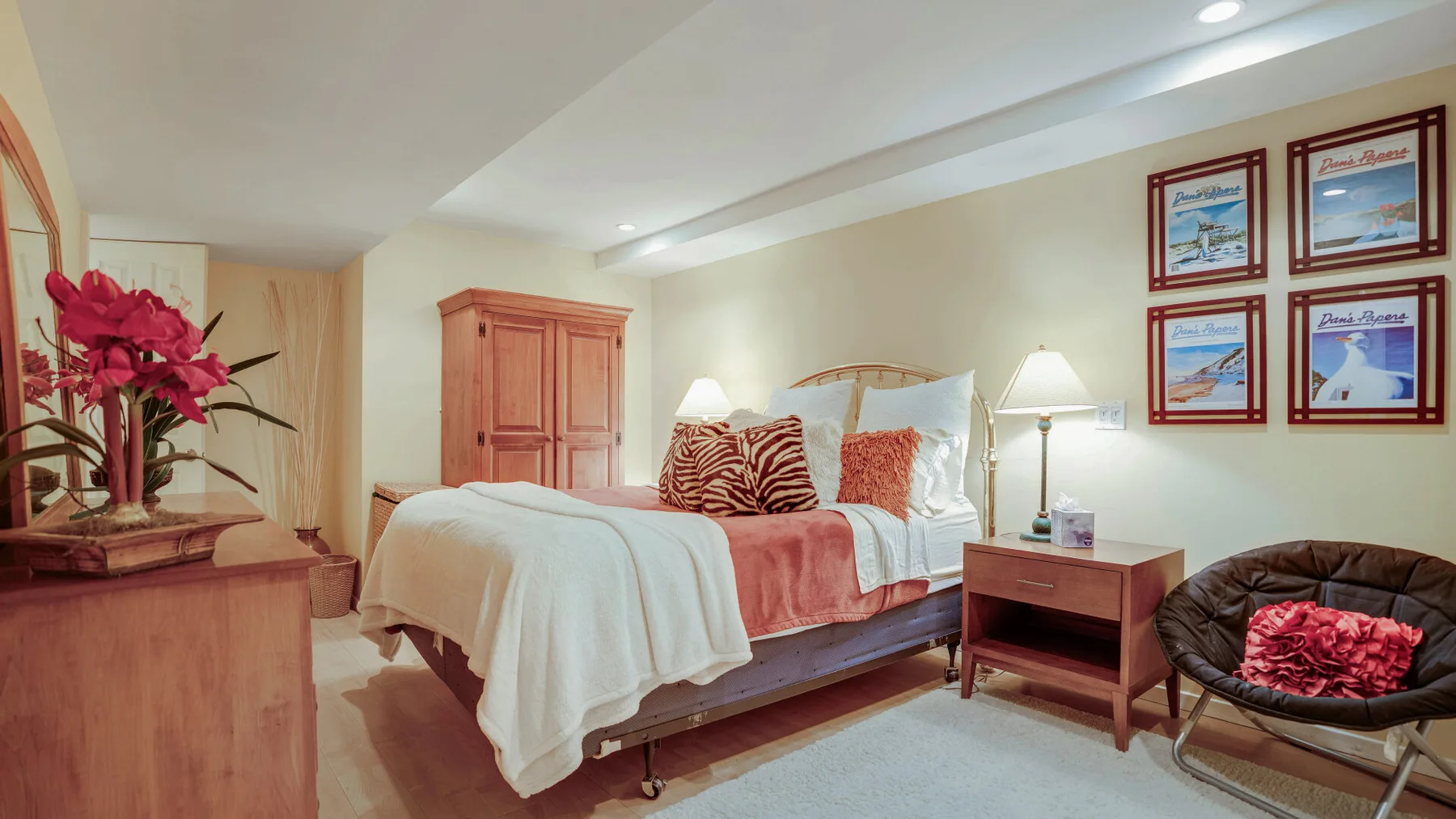 Un dormitorio con una cama, una mesita de noche y cuadros en la pared.