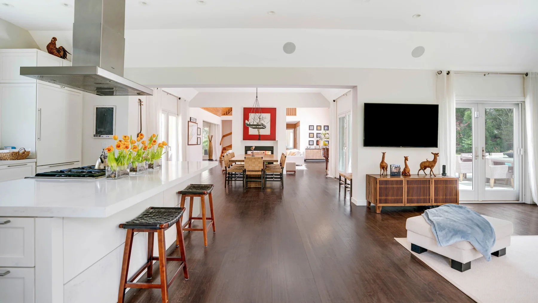 Una sala-comedor de planta abierta con una isla de cocina y asientos.