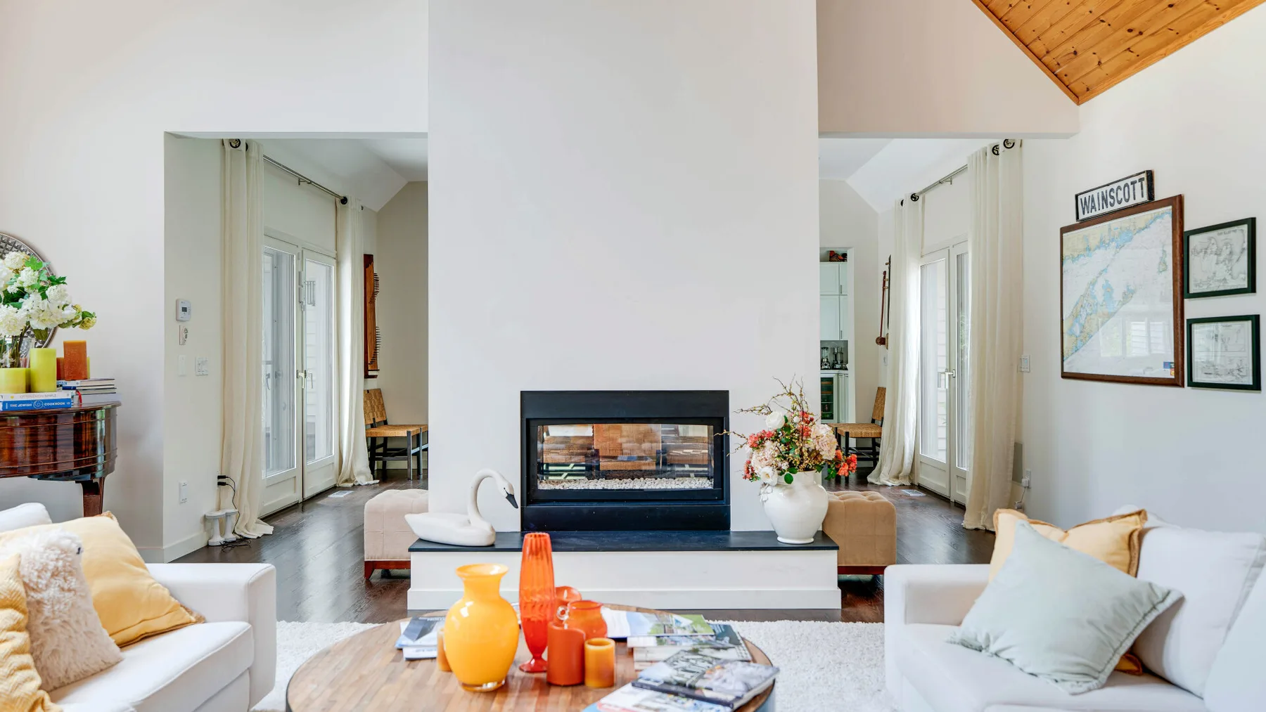 Una sala luminosa con asientos alrededor de una chimenea y una mesa de centro baja.