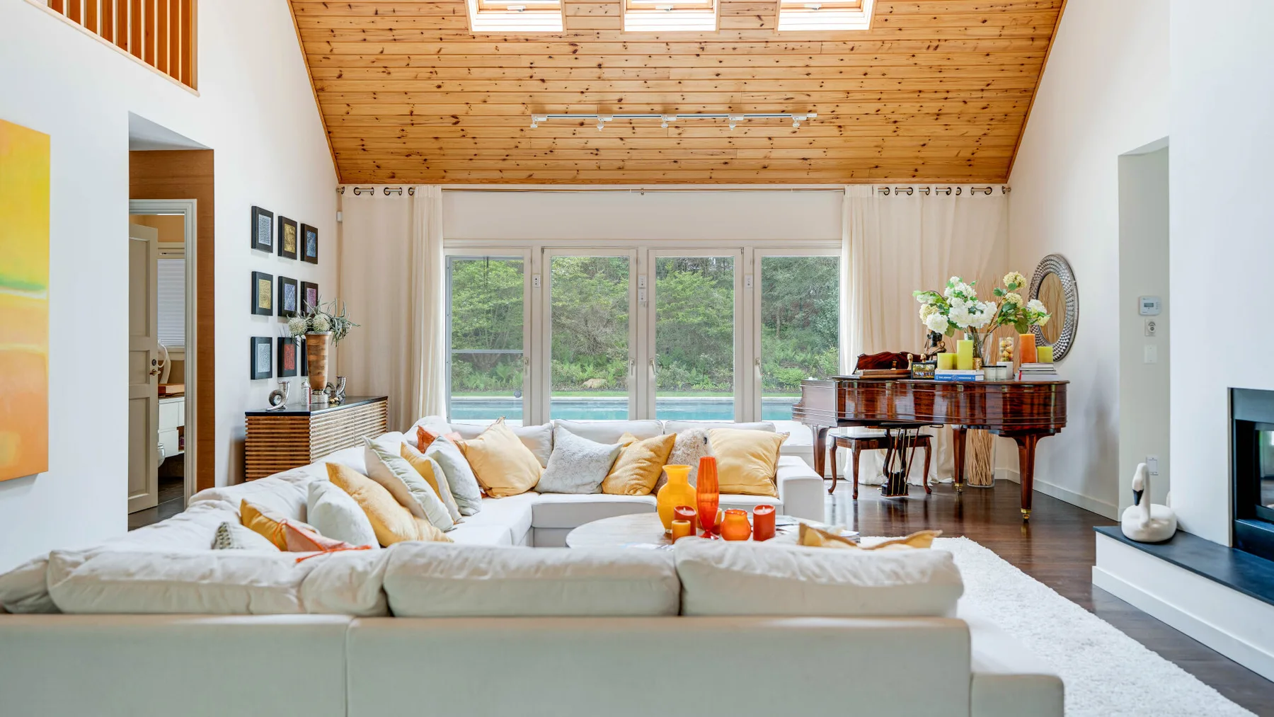 Una sala luminosa con una zona de asientos bajo un techo inclinado de madera.