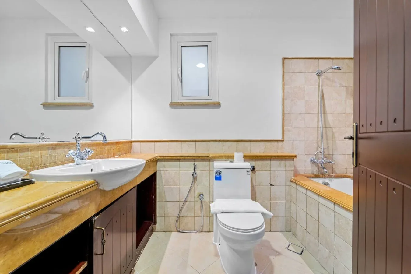 Un baño con lavabo, inodoro y zona de ducha con azulejos.