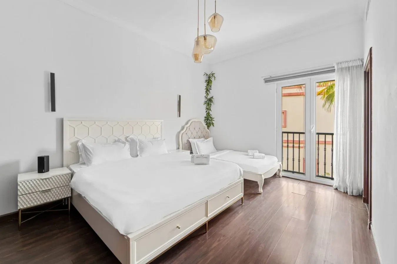 Un dormitorio luminoso con una cama grande y una puerta de vidrio que da a un balcón.