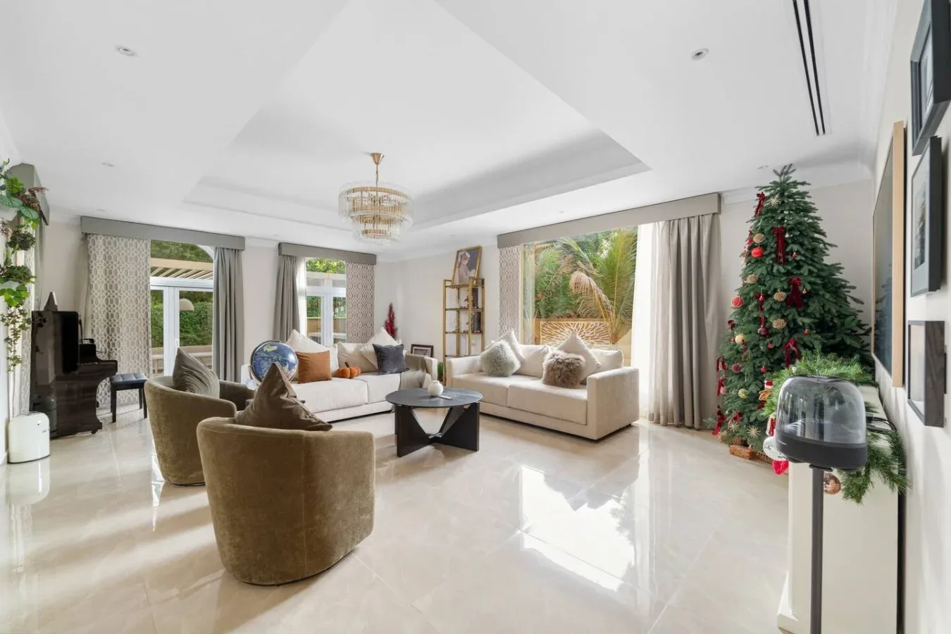 Una luminosa sala de estar con asientos alrededor de una mesa baja y un árbol de Navidad decorado.