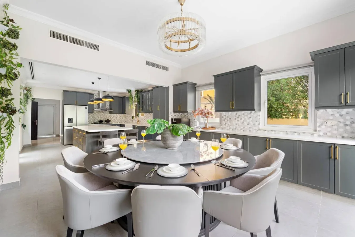 Una luminosa cocina y comedor con una mesa redonda preparada para comer.