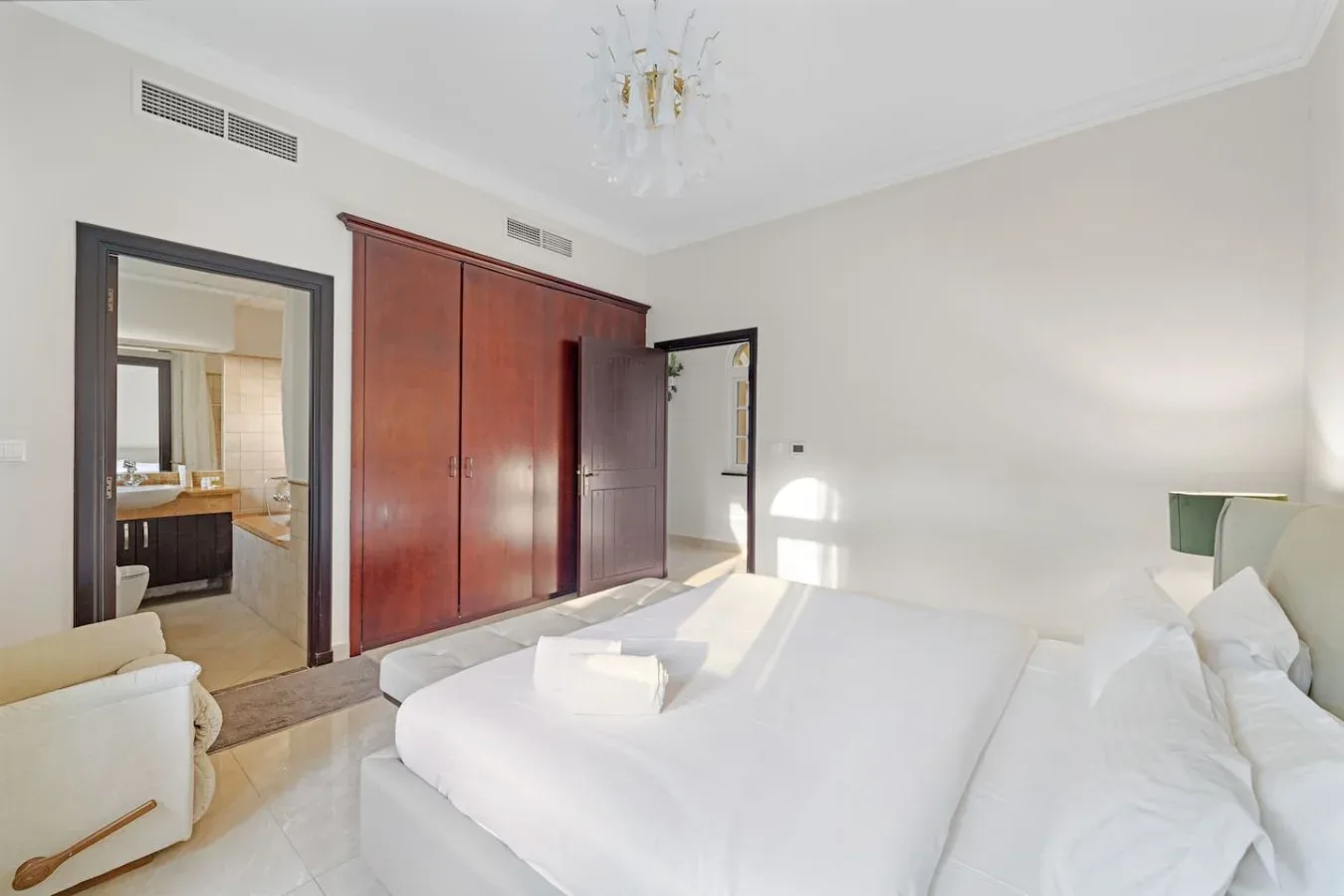 Un dormitorio luminoso con una cama grande y armarios de madera empotrados.
