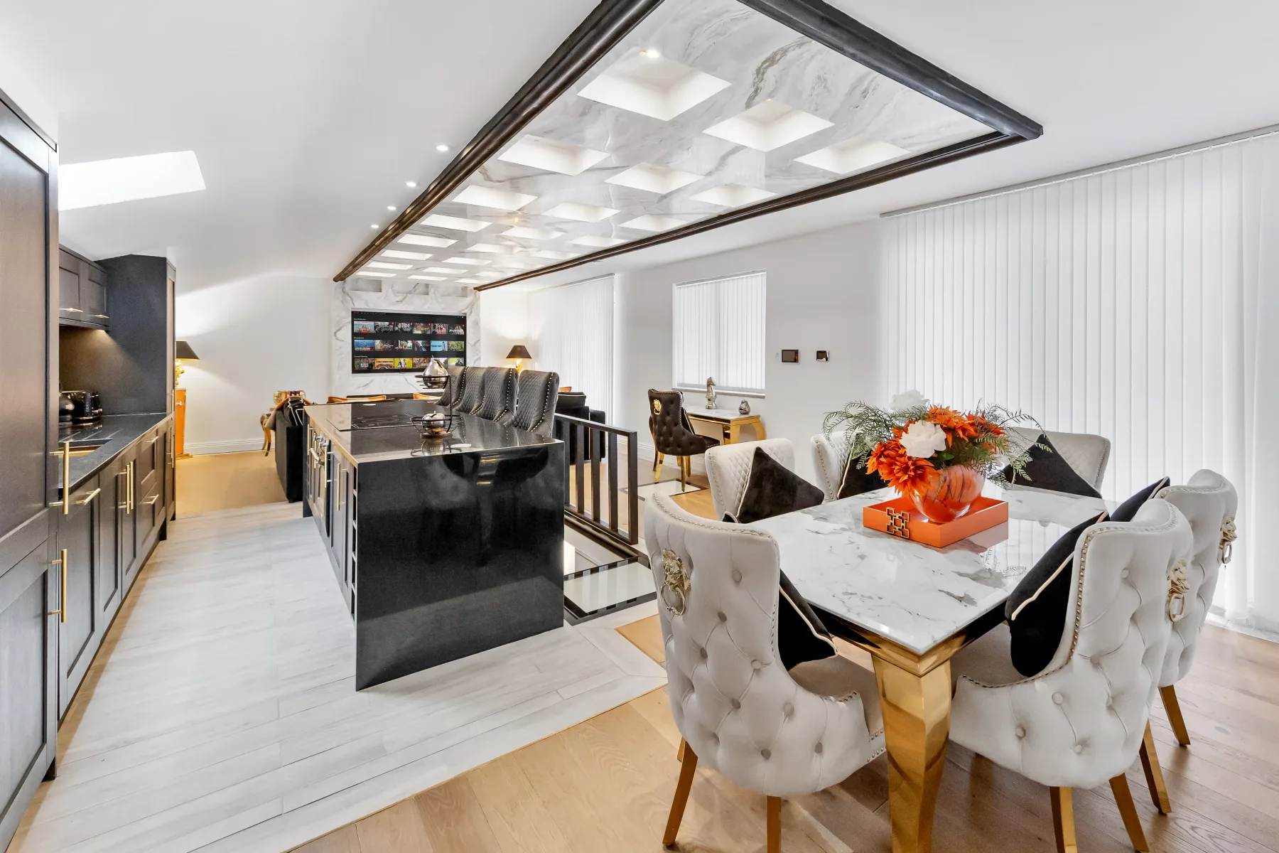 Cocina y comedor de planta abierta con una isla central y una mesa de comedor.