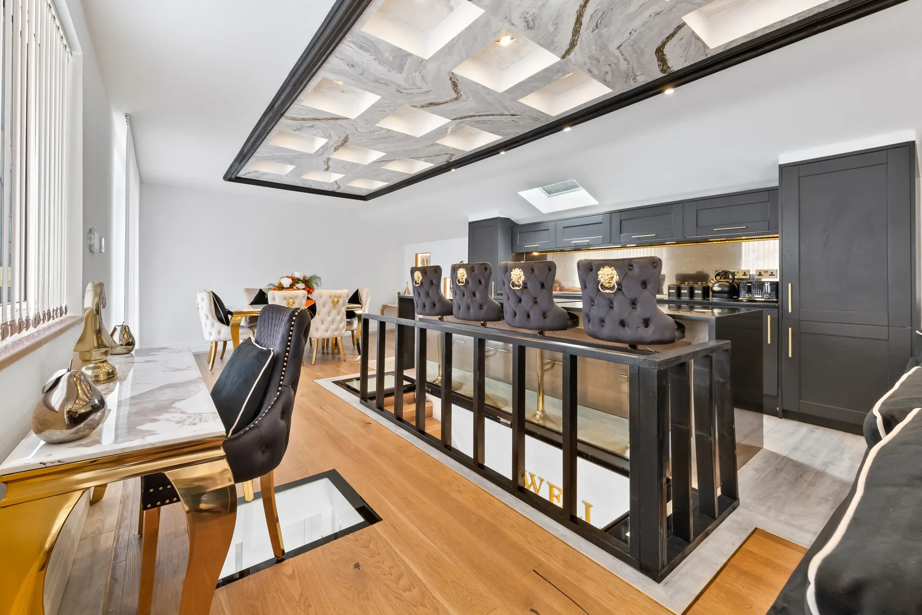 Una cocina moderna y zona de comedor con una gran isla central y una mesa de comedor.