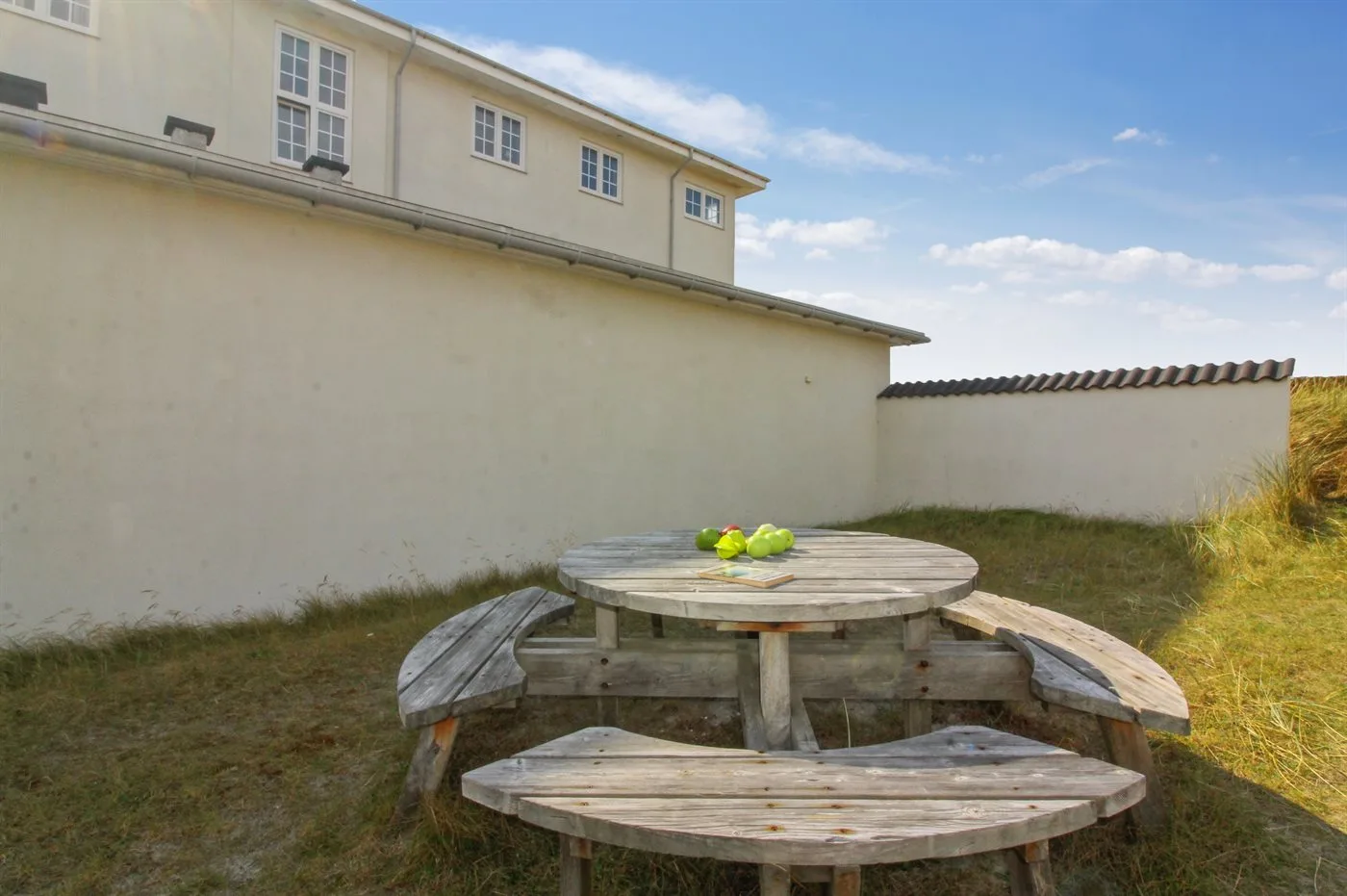 Una zona de estar al aire libre con una mesa redonda de picnic de madera.