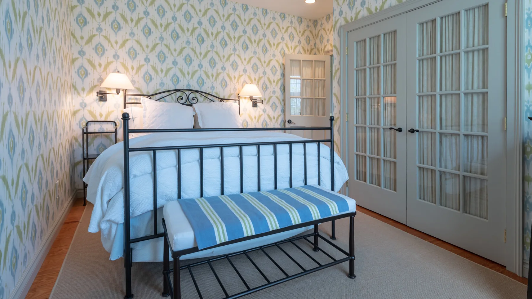 A bedroom with a black metal bed and blue-striped bedding.