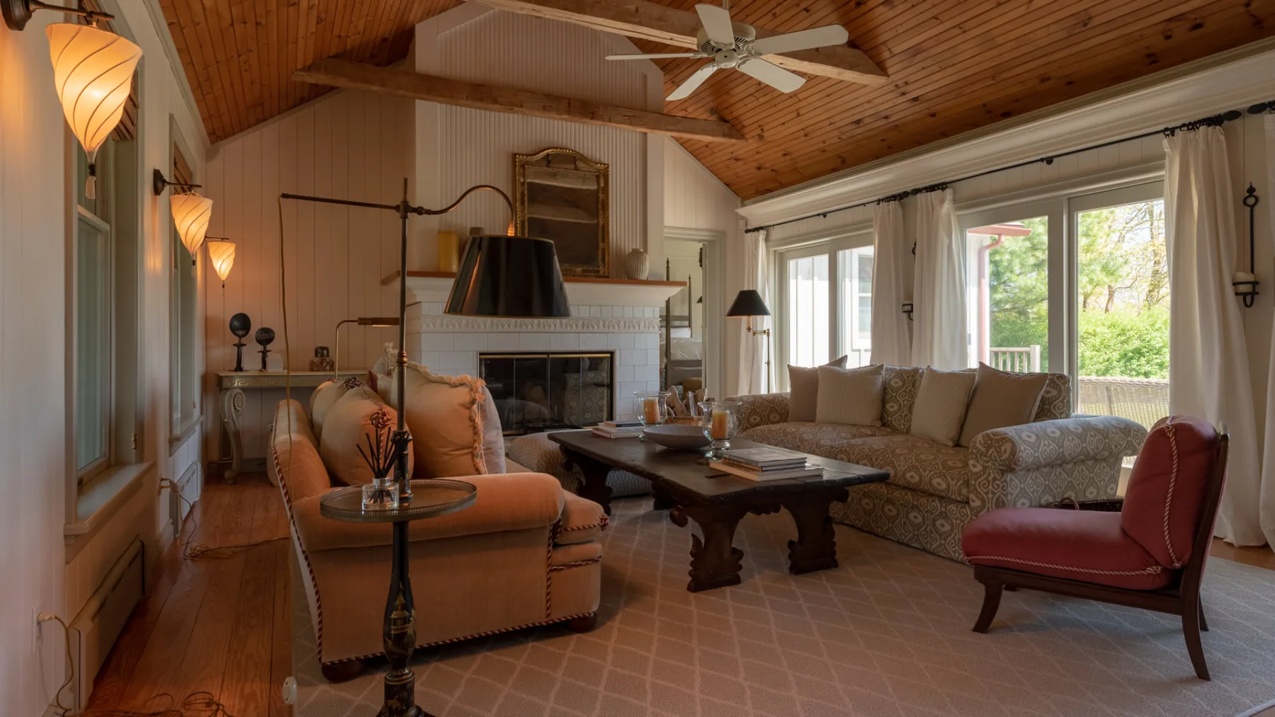 A living room with seating arranged around a coffee table and fireplace.