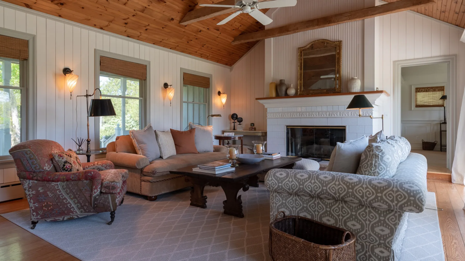 A living room with seating arranged around a coffee table and fireplace.