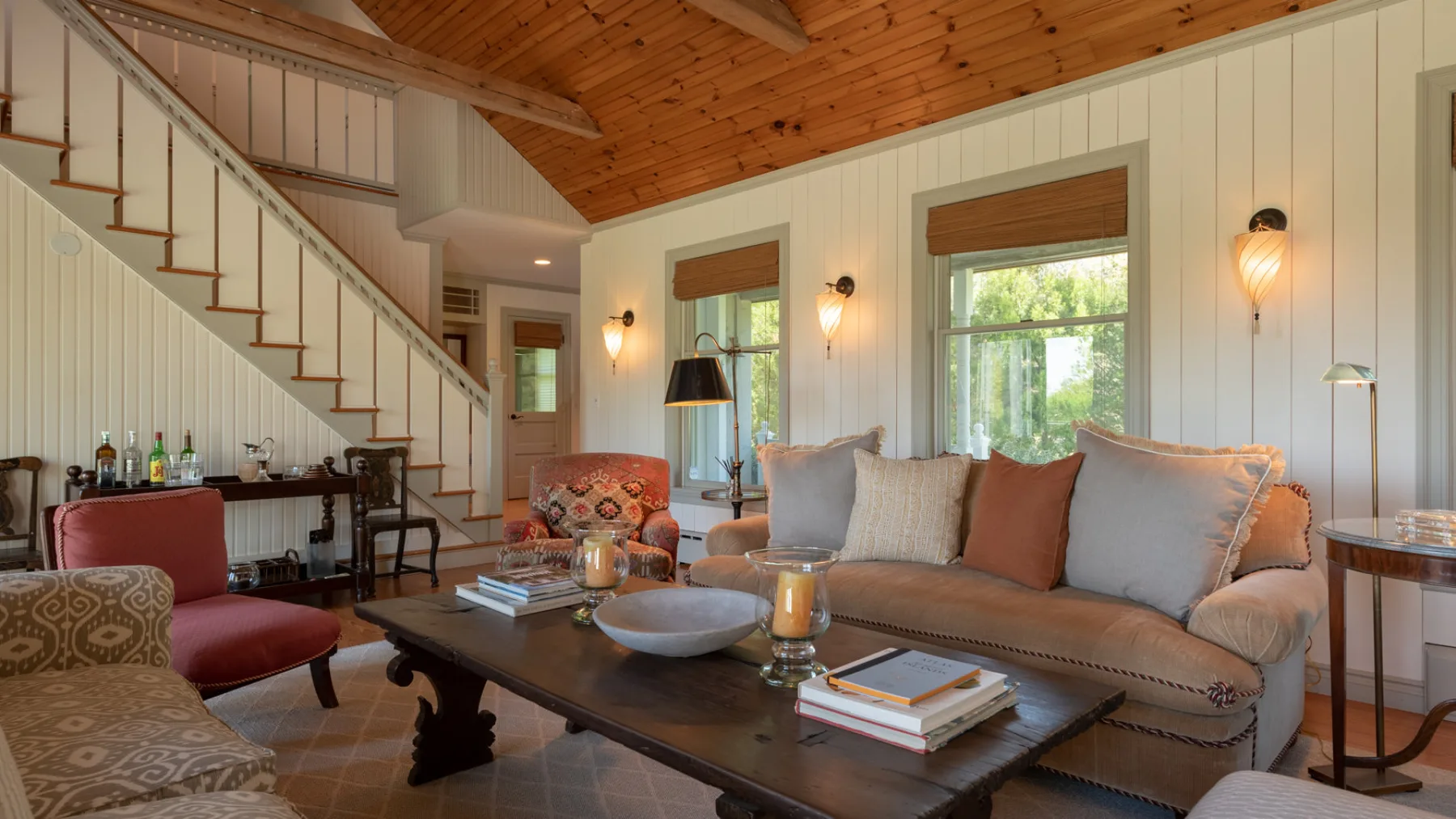 A living room with a long sofa, coffee table, and staircase.