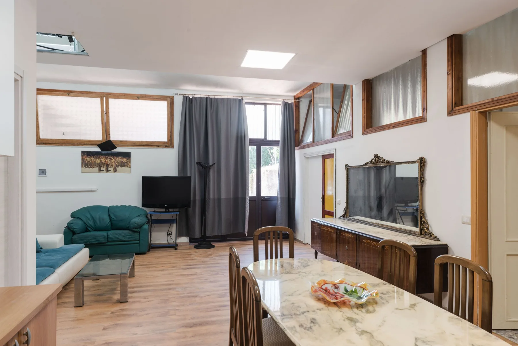 Una sala de estar con mesa de comedor, asientos y televisor.