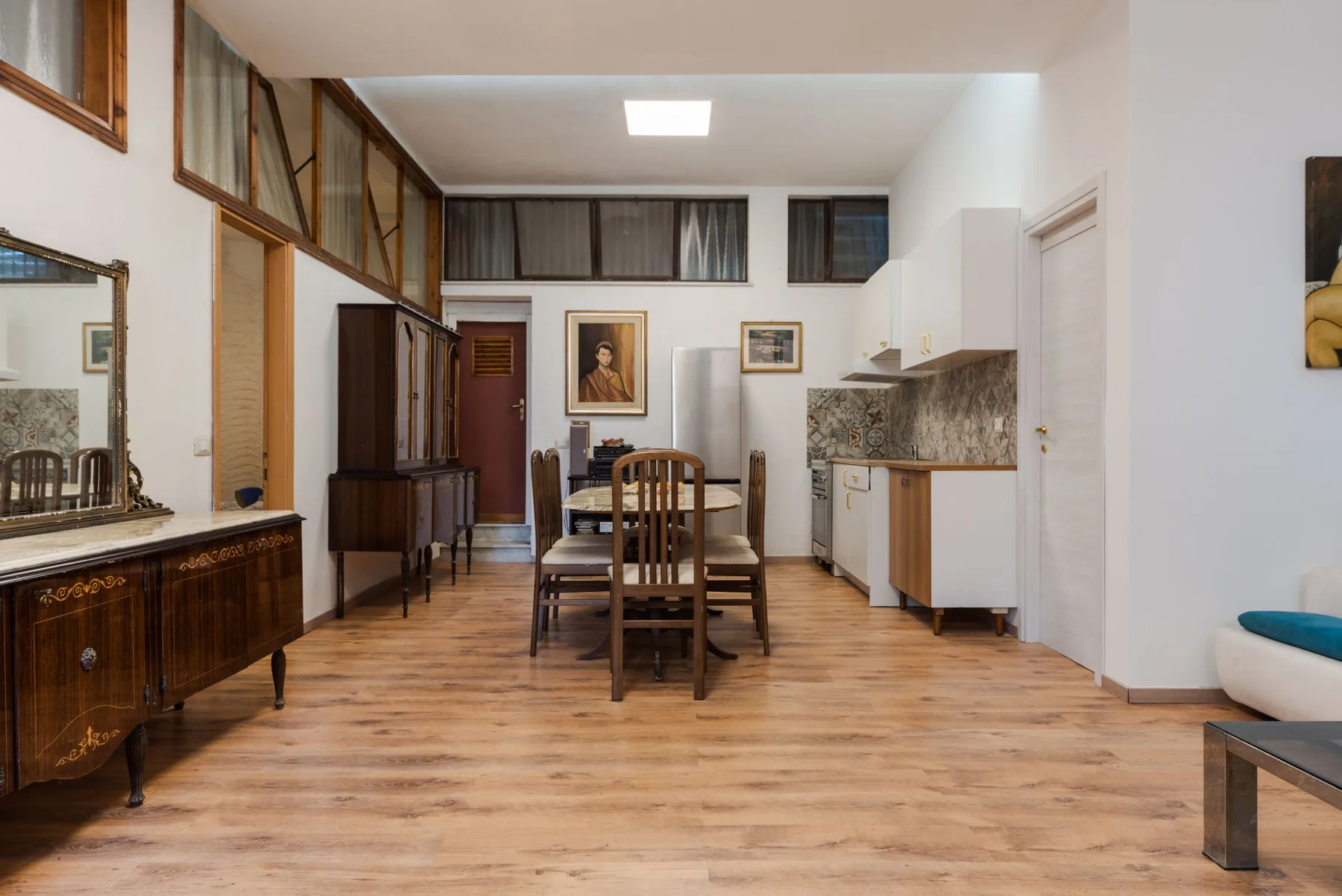 Un comedor con una mesa de madera y sillas junto a una cocina.