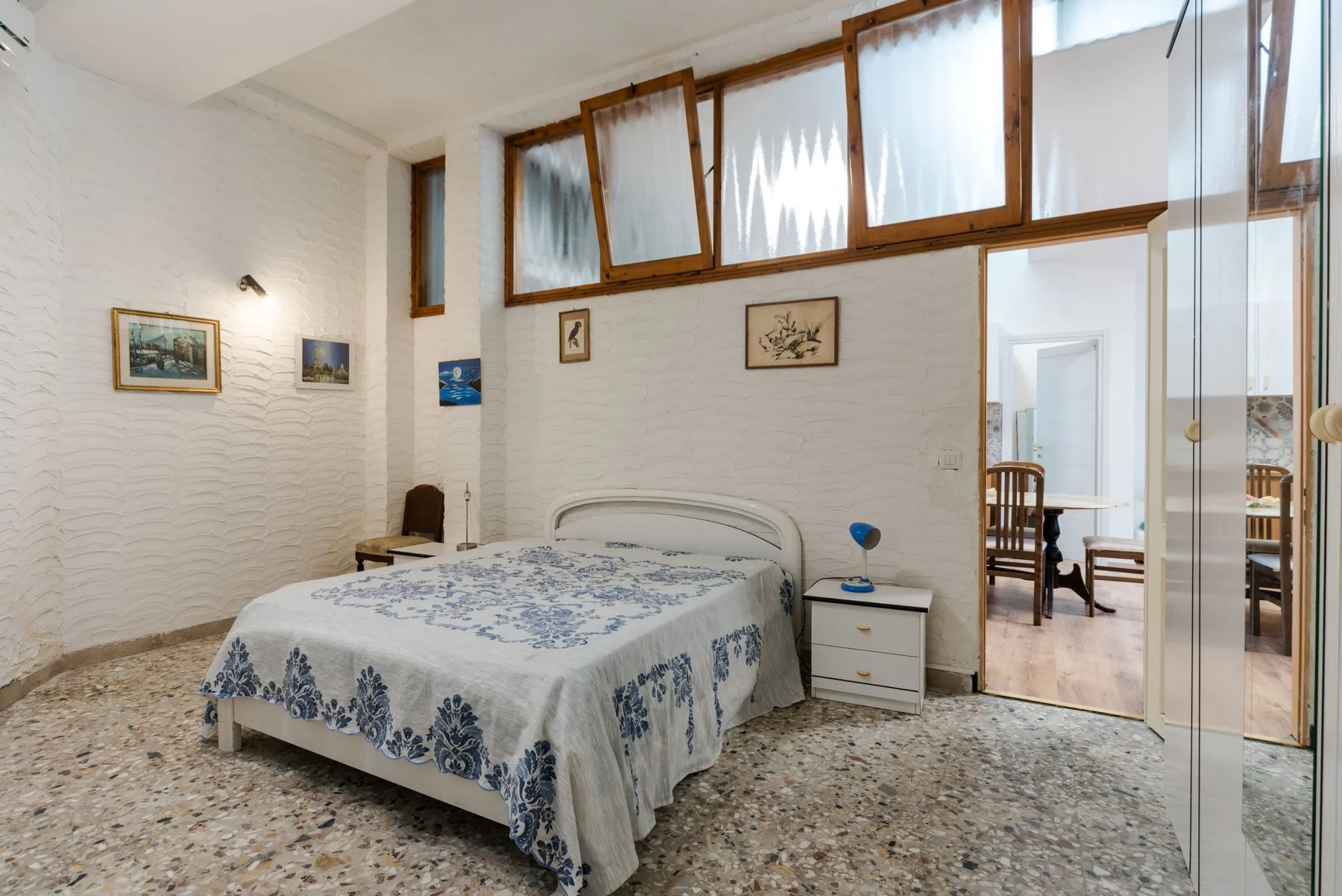 Un dormitorio con una cama cubierta con ropa de cama estampada en azul y blanco.
