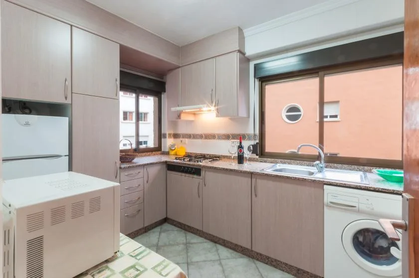 A kitchen with fitted cabinets, a sink, and a washing machine.