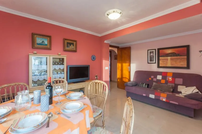 A dining and living room with a set table and seating area.