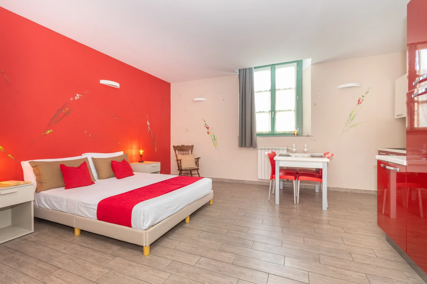 A bedroom with a large bed and a small table beside the window.