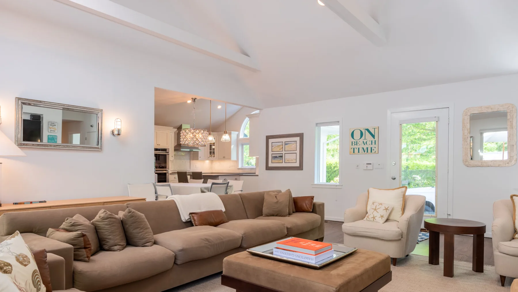 Una sala luminosa con sofá seccional, sillón y mesa de centro.
