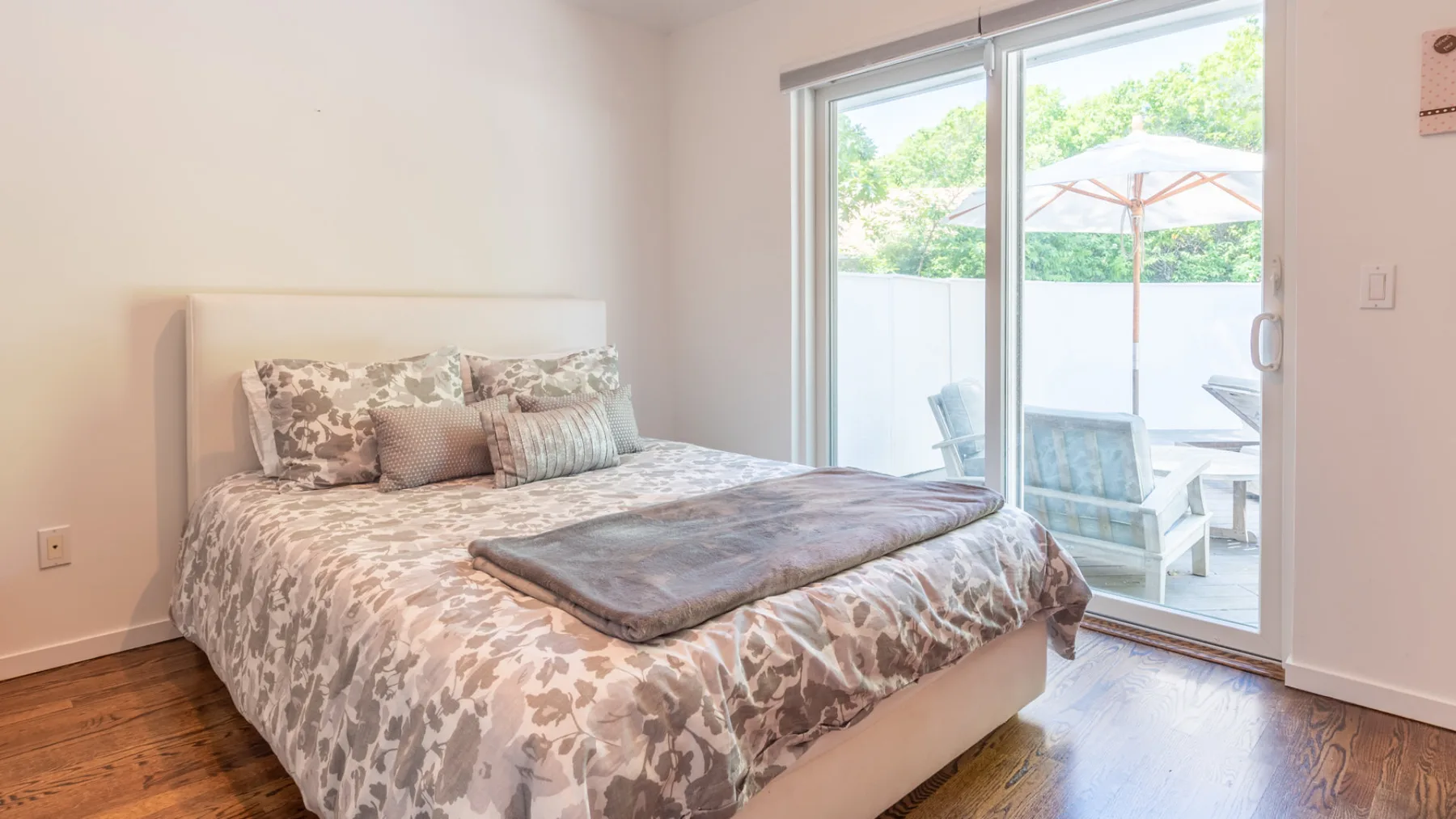 Un dormitorio con una cama junto a puertas corredizas de vidrio que dan a un patio.