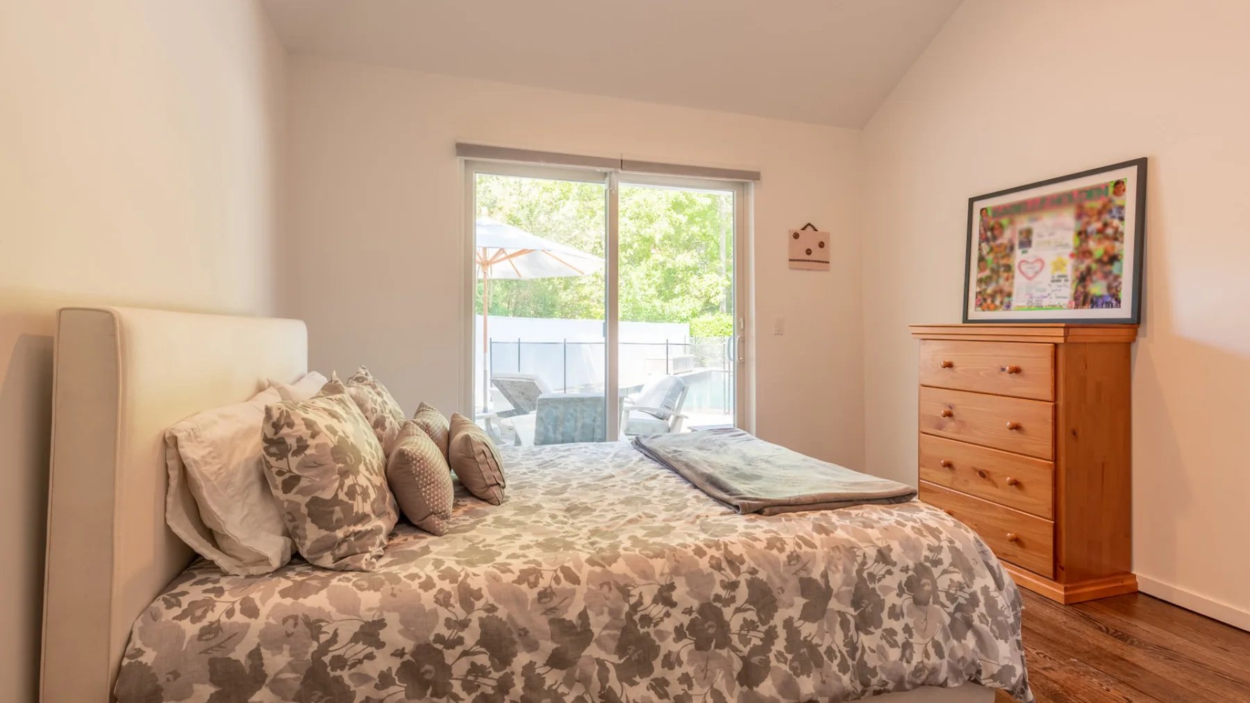 Un dormitorio con una cama estampada junto a una ventana grande.