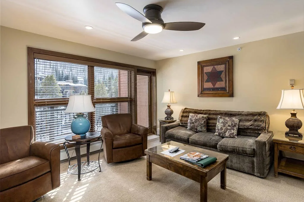 A living room with a sofa, armchairs, and a coffee table.