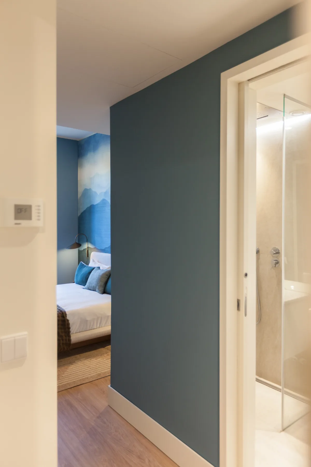 Un pasillo da a un dormitorio, con un baño visible a través de una puerta.