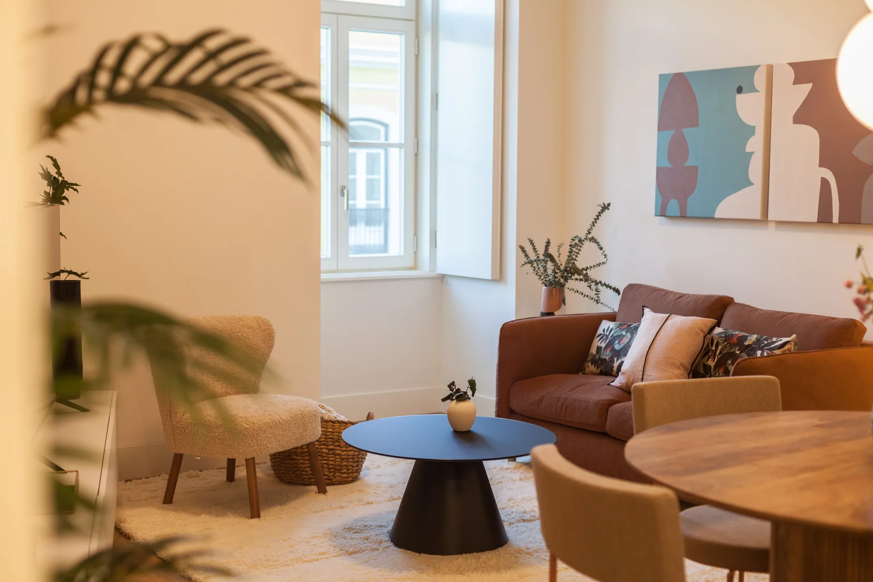 Una sala de estar con asientos, una mesa de centro y arte abstracto en la pared.