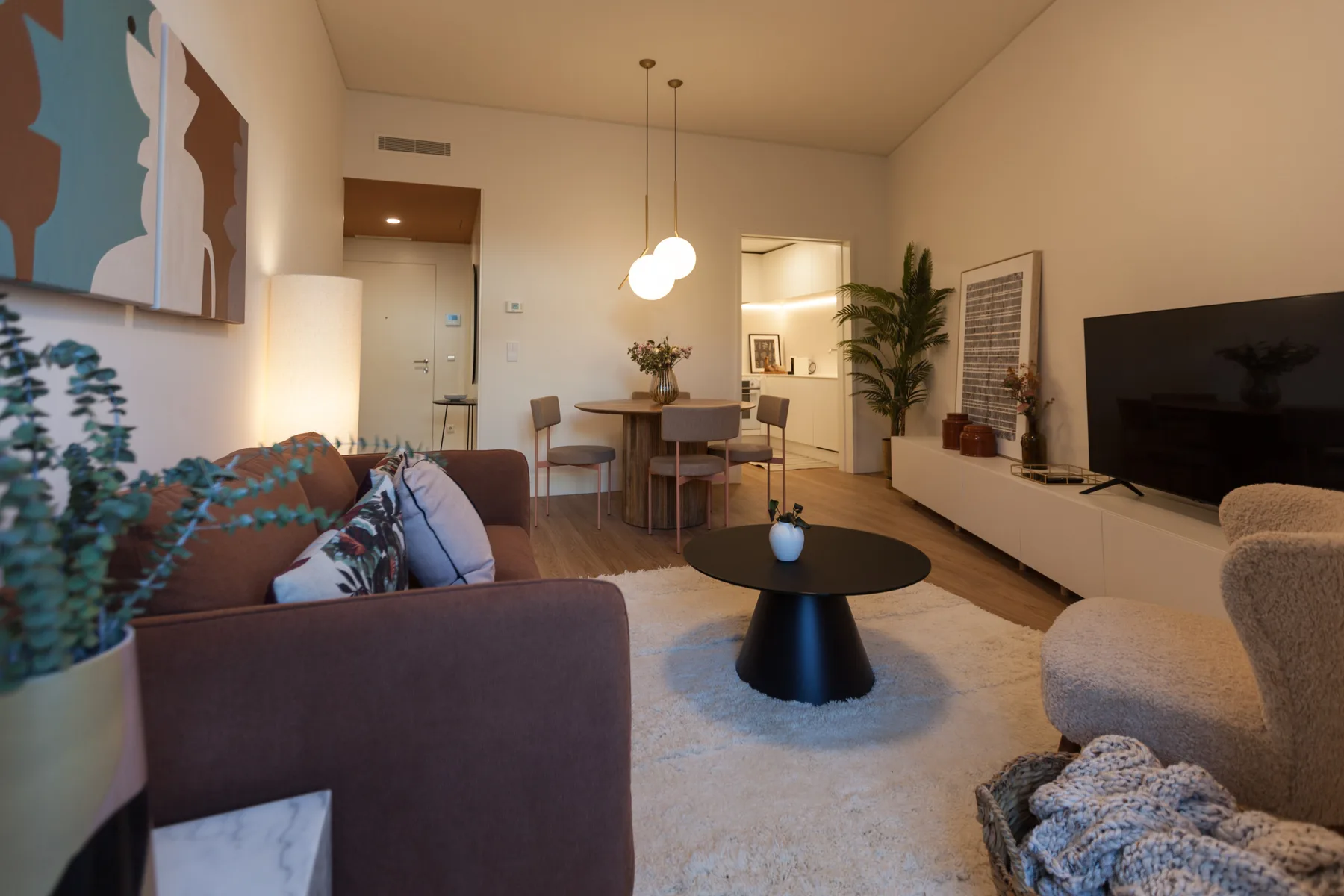 Sala de estar con asientos, una mesa de centro y un comedor.