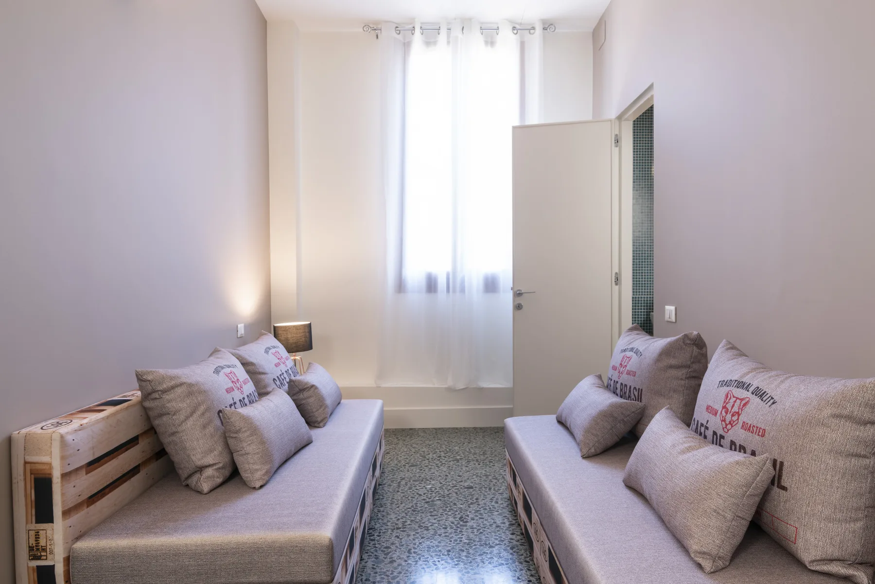 Una sala de estar luminosa con dos sofás enfrentados bajo una ventana.