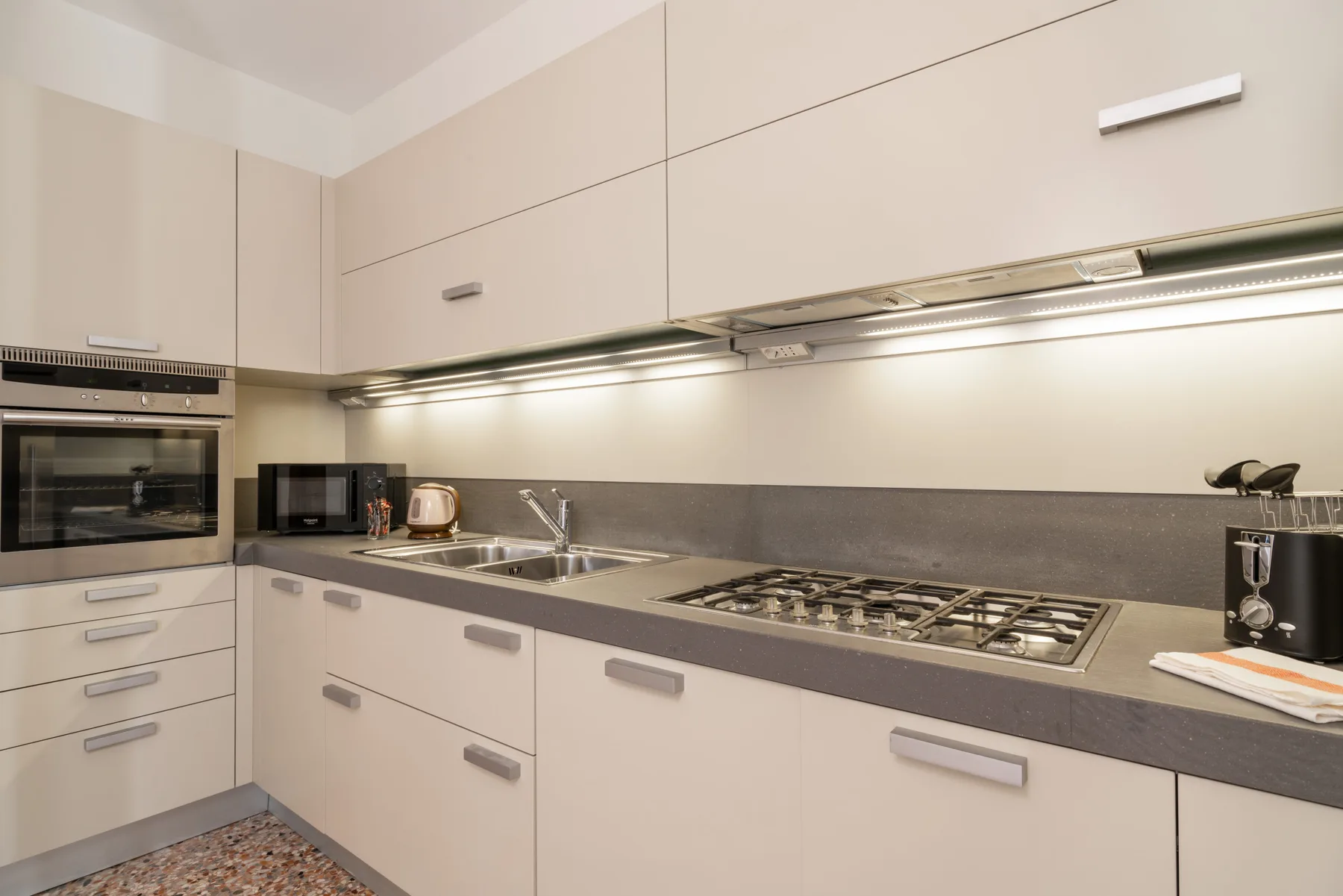 Una cocina moderna con gabinetes claros, una encimera y una placa de cocción.