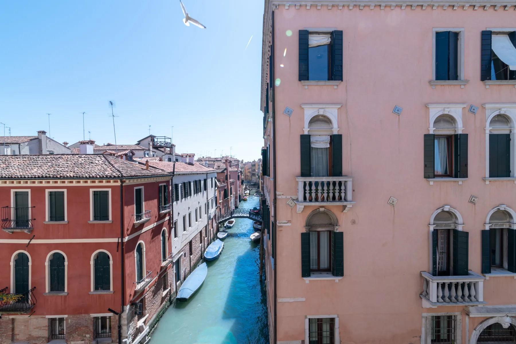 Un canal pasa entre edificios coloridos, con barcos junto al agua.