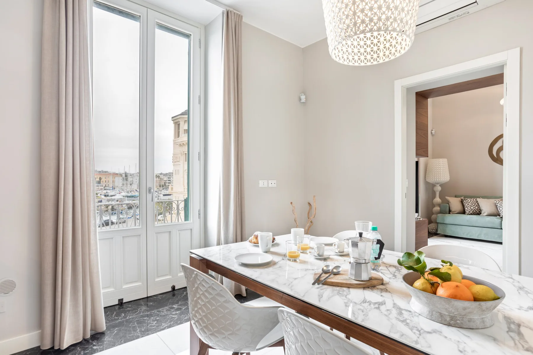 A bright dining area with a set table beside tall windows.