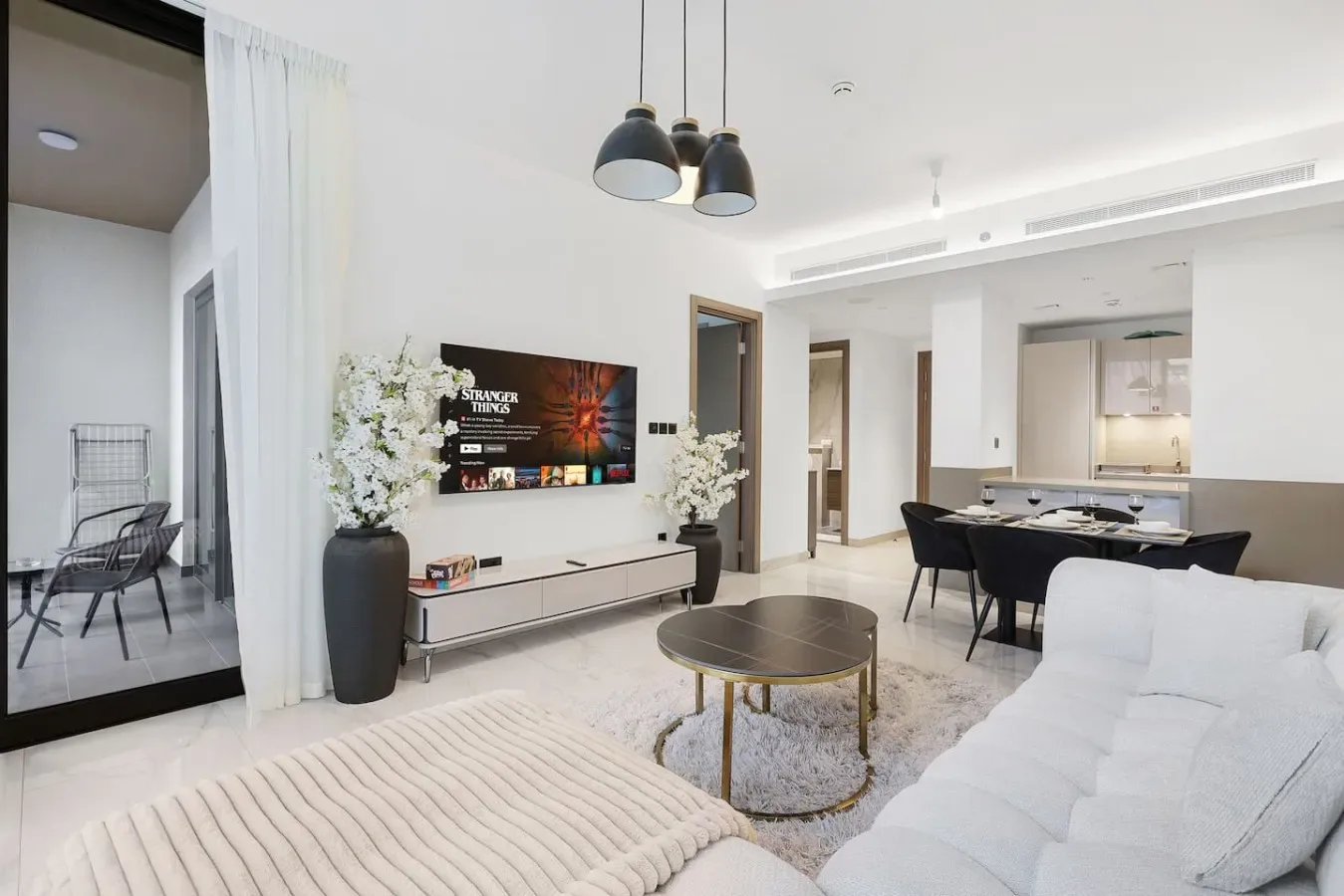 Una sala-comedor de planta abierta con asientos, un televisor y una mesa.