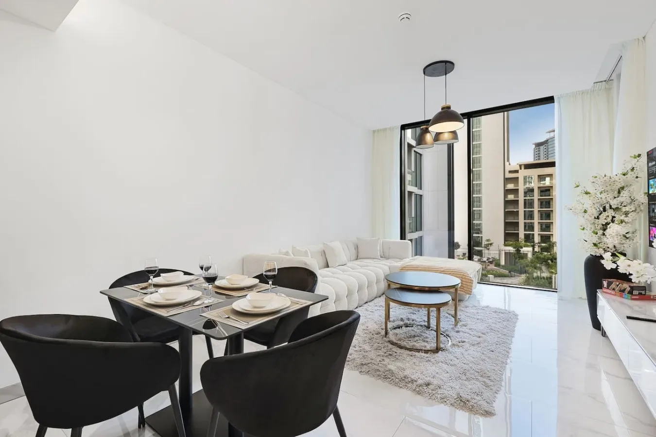 Una luminosa sala-comedor de concepto abierto con asientos junto a grandes ventanas.