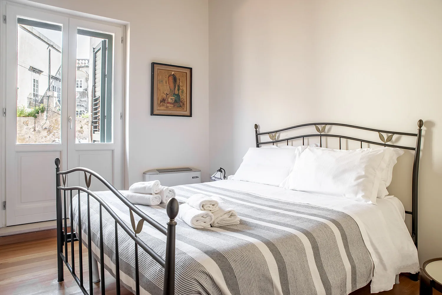 Dormitorio con una cama bien tendida y una ventana grande.
