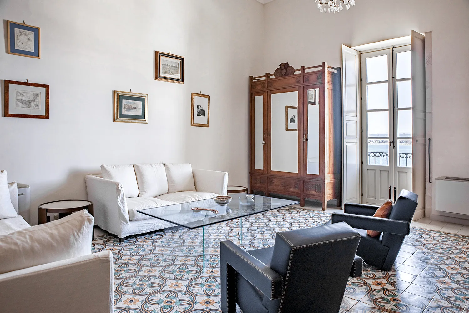 Una sala luminosa con asientos, cuadros enmarcados y una mesa de centro de vidrio.