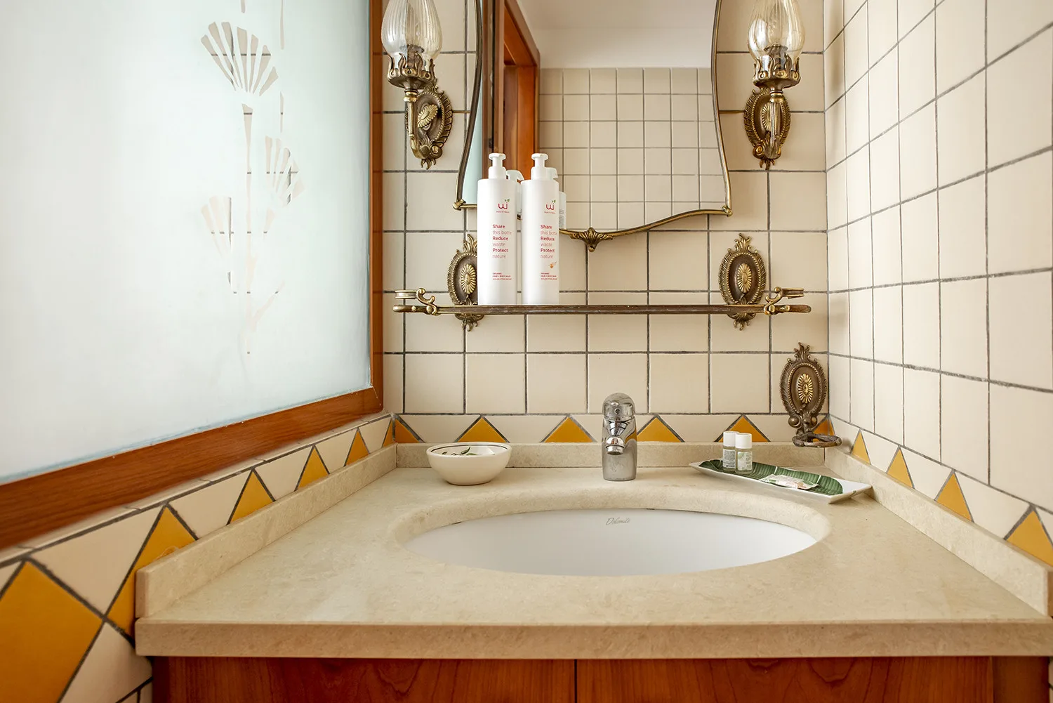 Un tocador de baño con azulejos, lavabo integrado y espejo encima.