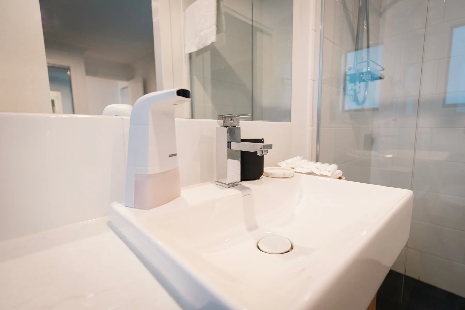 Un lavabo de baño con grifo y dispensador de jabón.