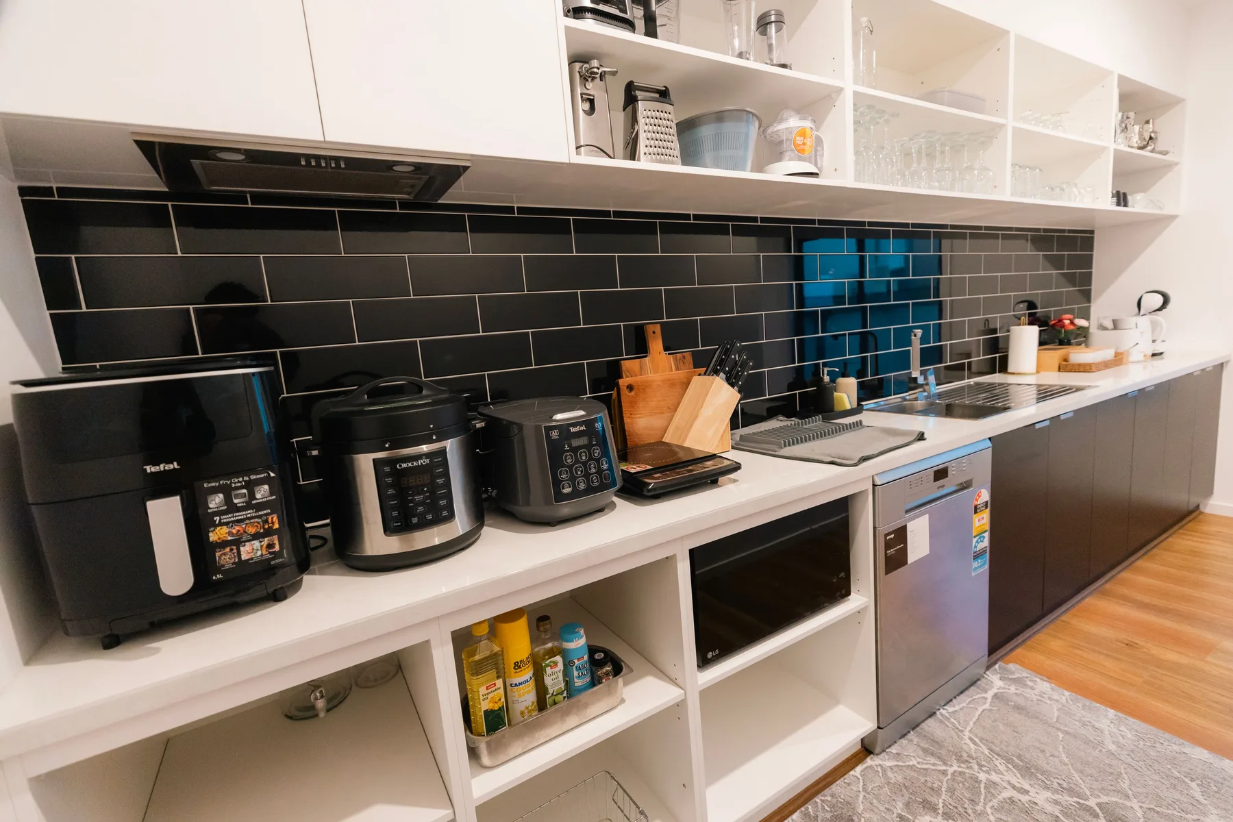 Una cocina moderna con electrodomésticos de encimera y un salpicadero de azulejos.
