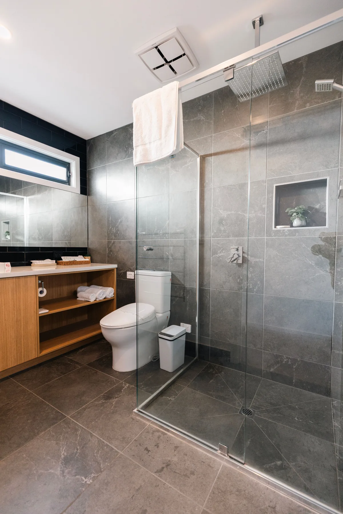 Un baño moderno con lavabo, inodoro y ducha de vidrio.