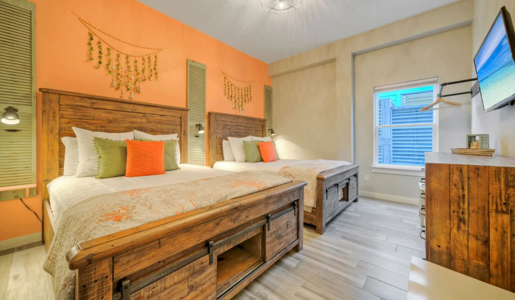Un dormitorio con dos camas, cojines de colores y muebles de madera.