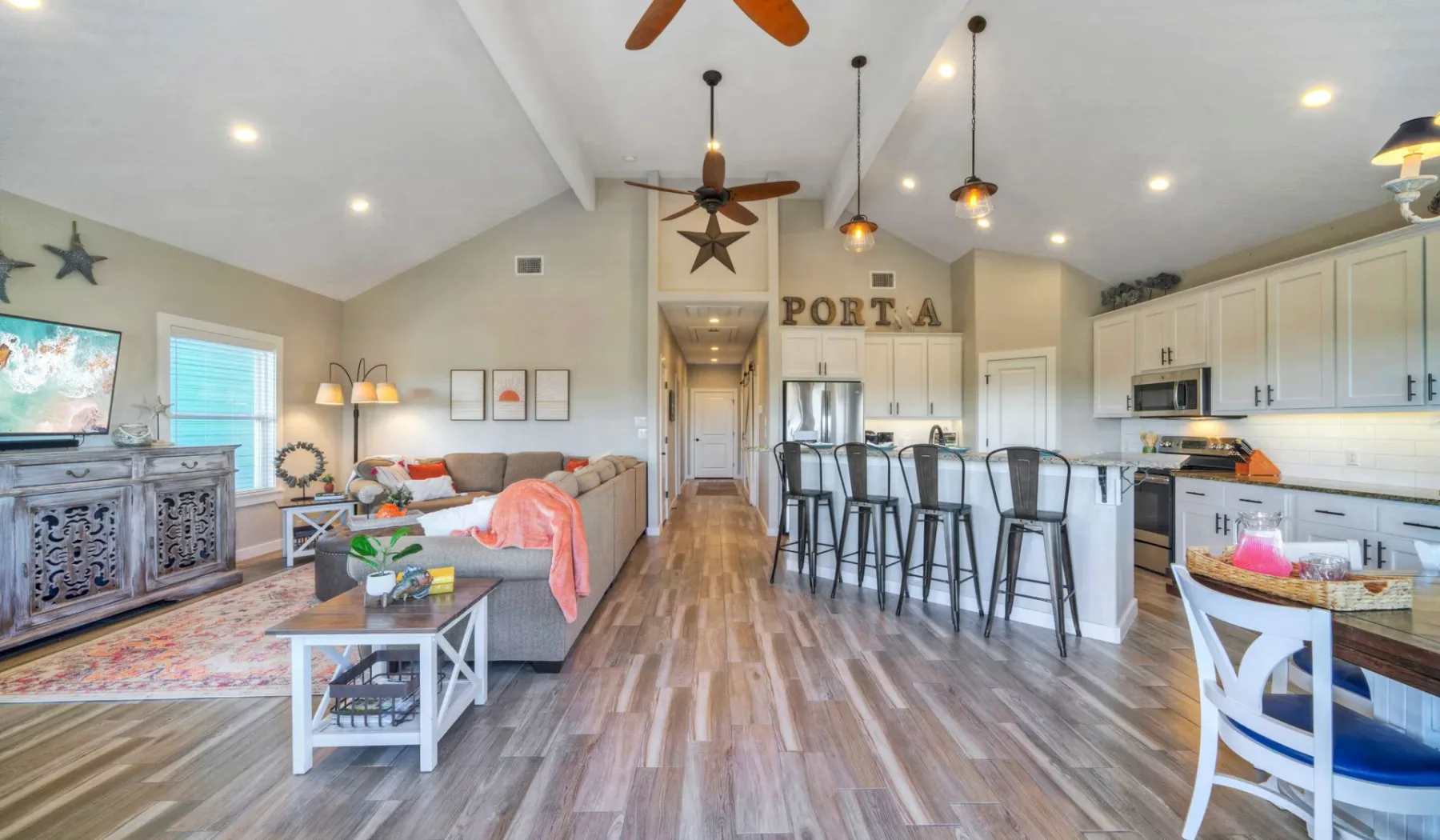 Sala de estar y cocina de concepto abierto con una isla y asientos.