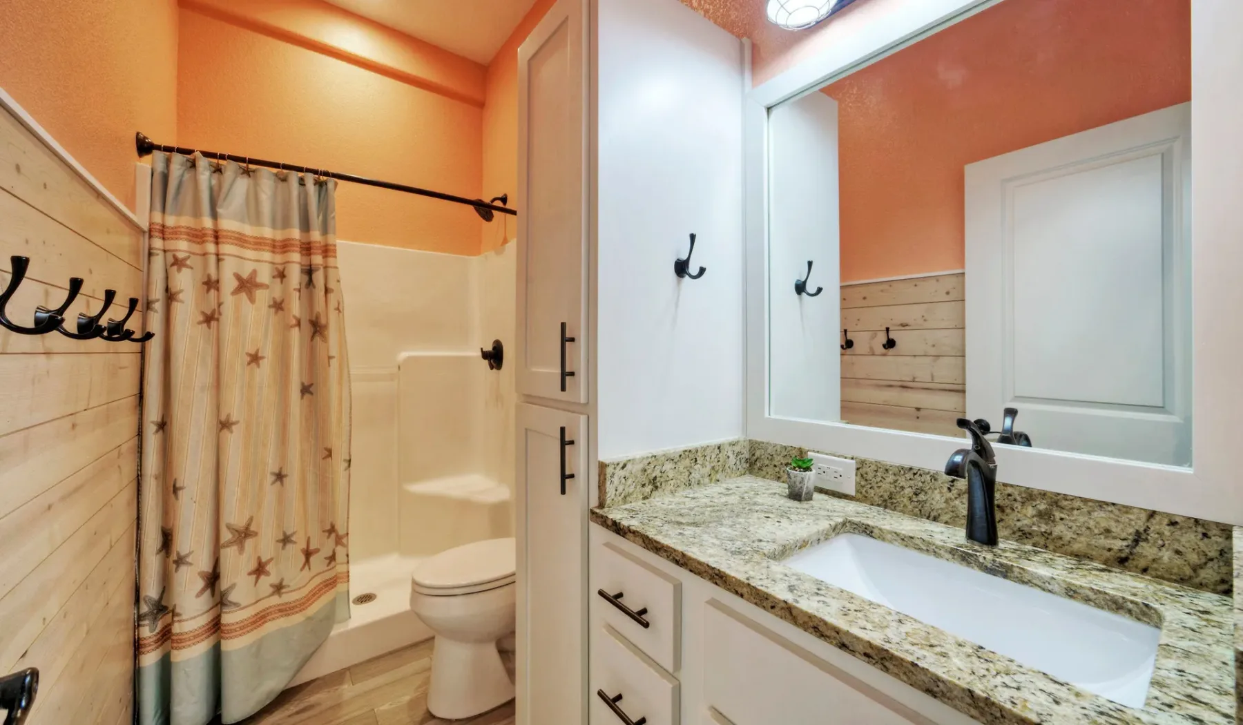 Un baño con bañera, cortina de ducha y lavabo con mueble.
