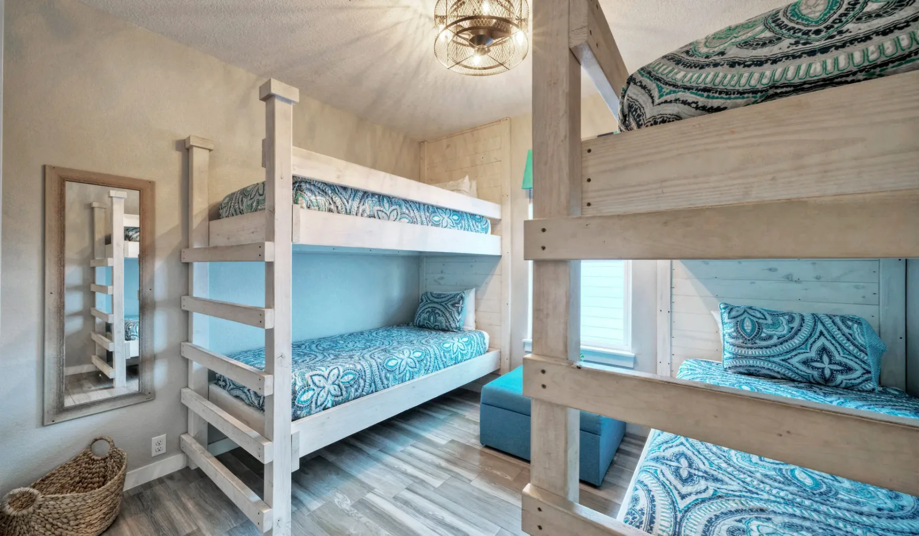 Un dormitorio con dos literas de madera y ropa de cama azul estampada.