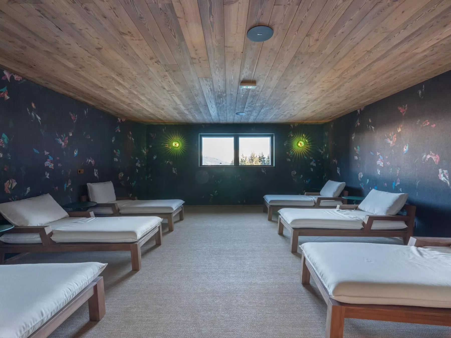 Una sala de relajación con tumbonas acolchadas dispuestas junto a las paredes.