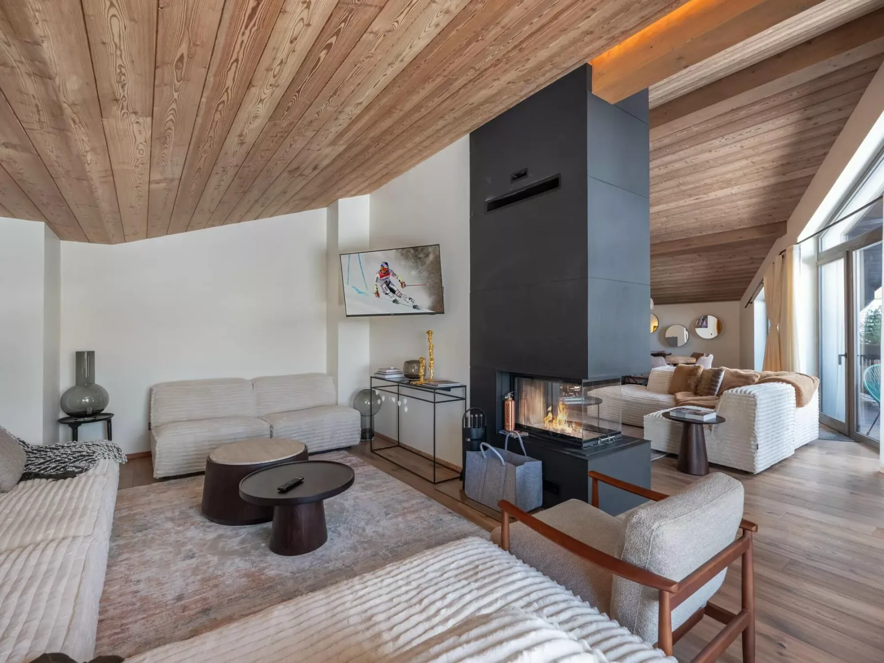 A living room with seating arranged around a central fireplace.