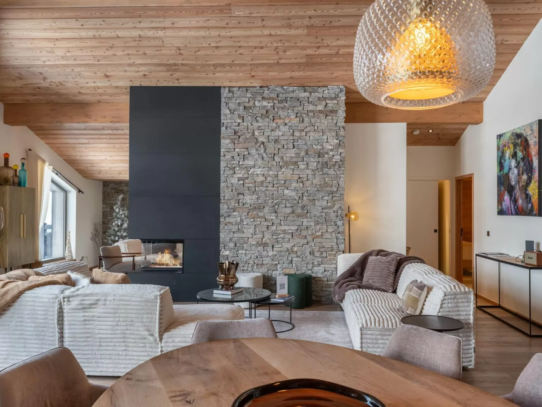 Una amplia sala de estar con chimenea de piedra y asientos alrededor de una mesa de centro.