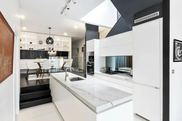 Una cocina moderna y luminosa con una gran isla y zona de comedor.